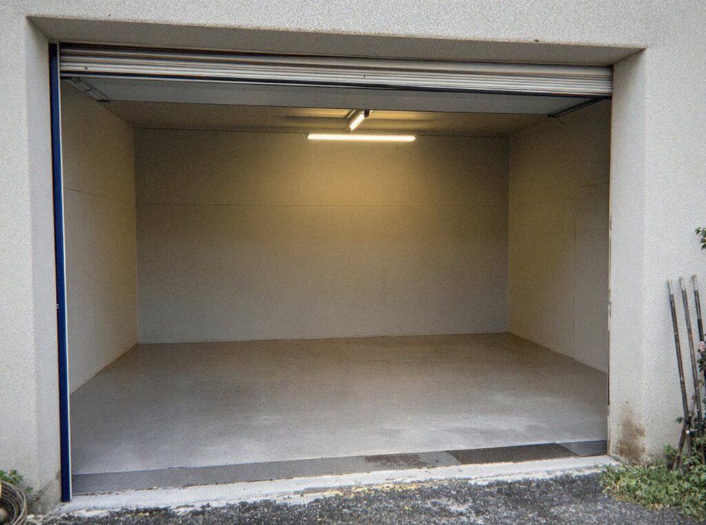 Le même garage vide et balayé après le débarras de la maison