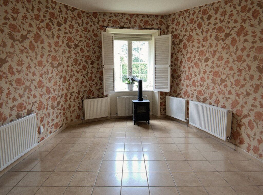Le même séjour vide, carrelage balayé, après le débarras de la maison